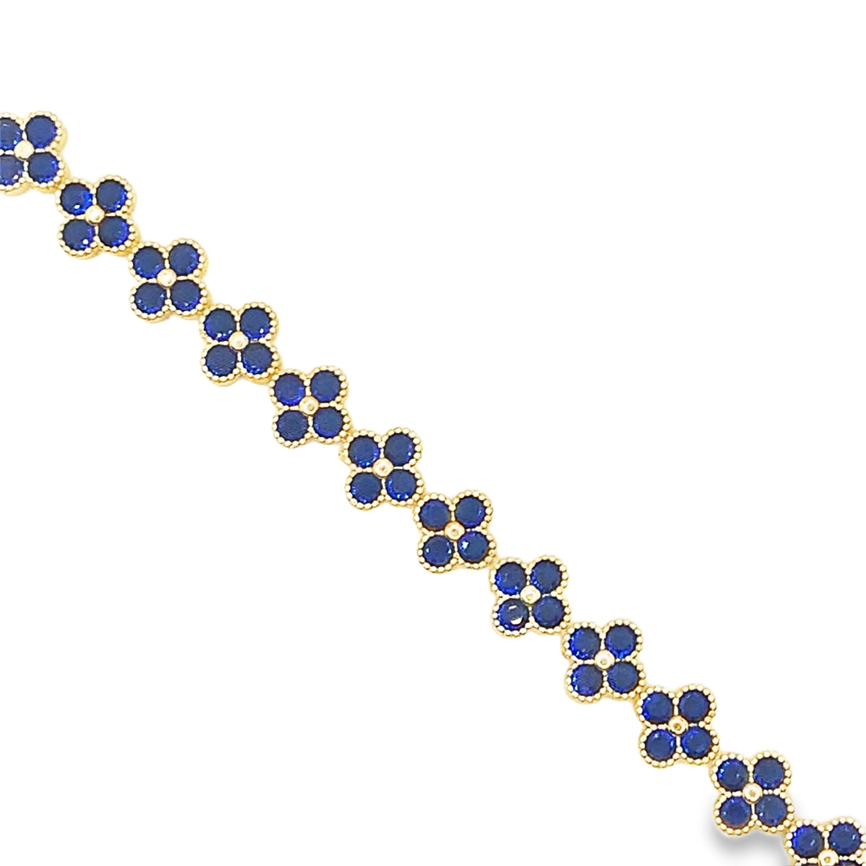 Bransoletka w kolorze żółtego złota z łańcuszkiem i akcentami z głęboko niebieskiego szafiru